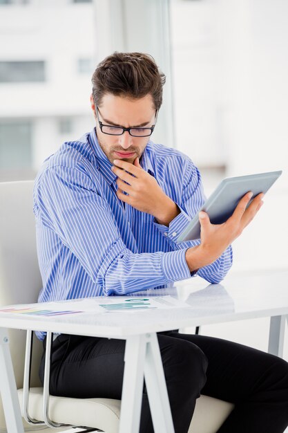 Businessman looking at document and using digital tablet