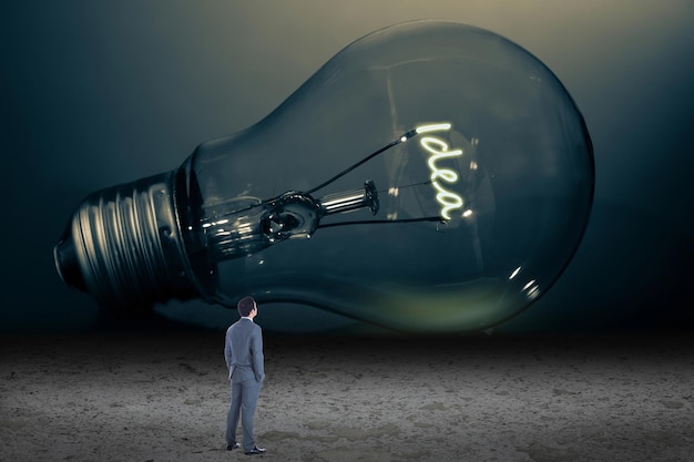 Businessman looking at giant light bulb