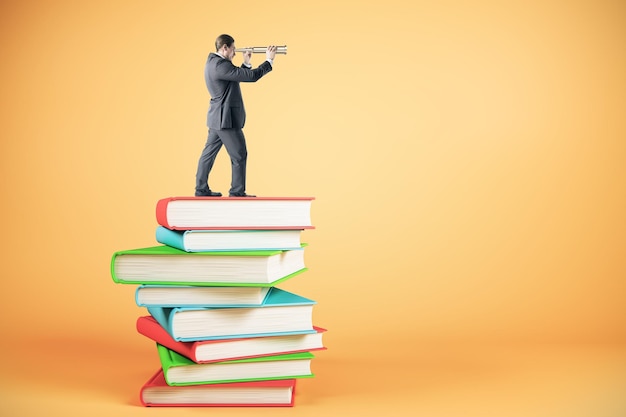 Businessman looking into the distance while standing on book stack Education research and finance concept