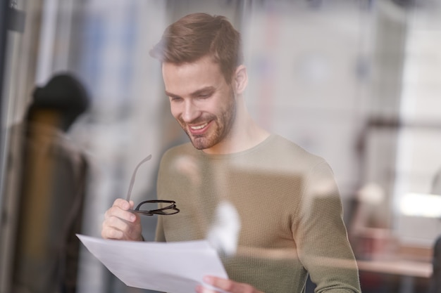 Businessman looking at statement with gladness and smile