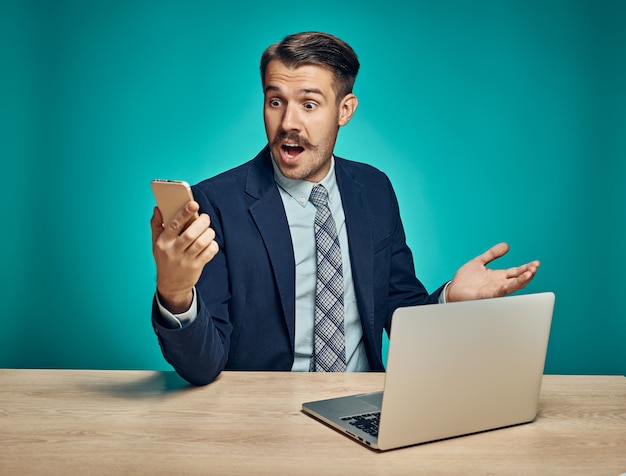 Businessman looking surprised at a mobile phone