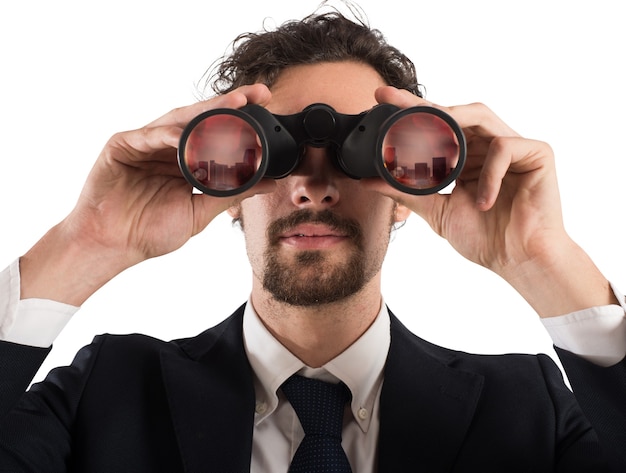 Businessman looking with binoculars the city. Looking to the future concept