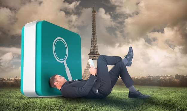 Businessman lying on the floor reading book  against paris under cloudy sky