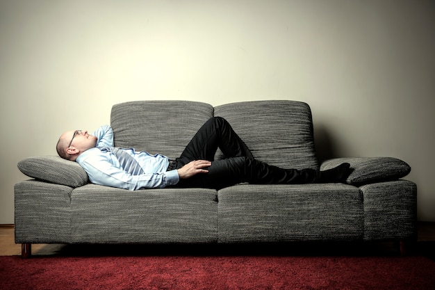 Businessman lying on a sofa