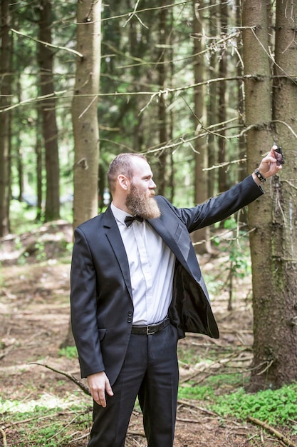 Businessman makes selfie on the background of pine forest