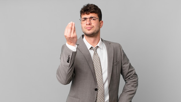 Businessman making capice or money gesture, telling you to pay your debts!