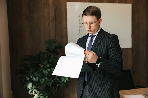 Businessman man in glasses examines documents in the office.