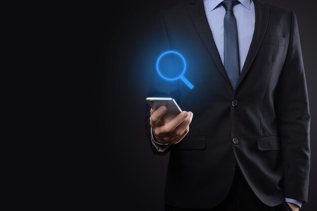 Businessman, man hold in hand magnifying glass icon.business, technology and internet concept