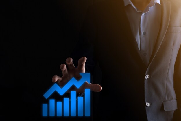 Businessman man holding a graph with positive profits growth. plan graph growth and increase of chart positive indicators in his business.more profitable and growing.