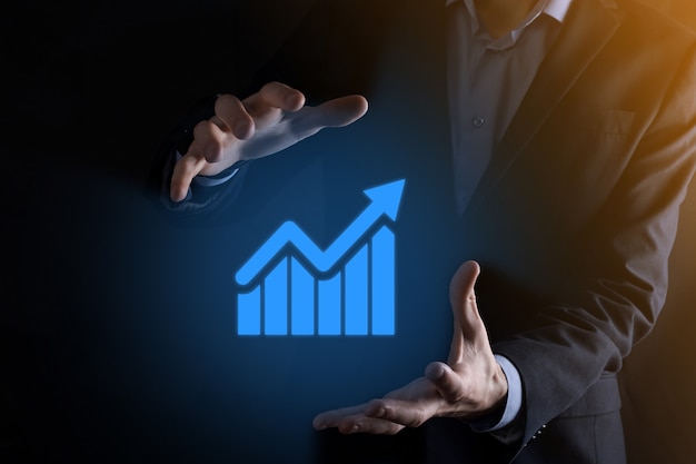 Businessman man holding a graph with positive profits growth