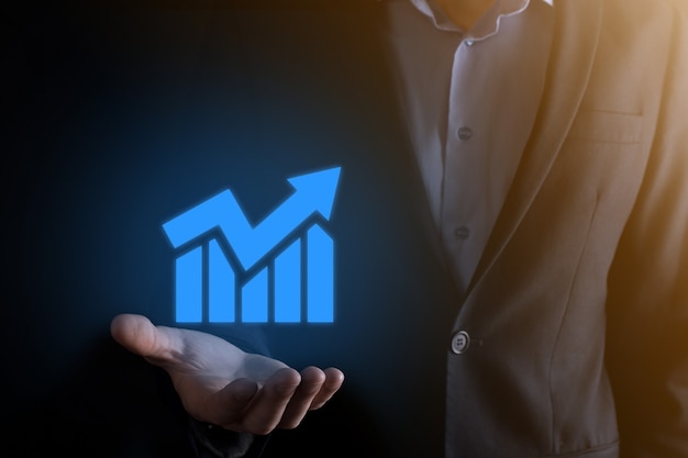 Businessman man holding a graph with positive profits growth