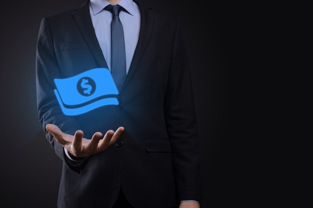 Businessman man holding money coin icon in his hands.Growing money concept for business investment and finance. USD or US dollar on dark tone background