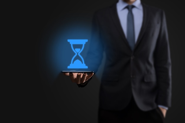 Businessman man holds in hand hourglasses icon. Time expires. A reminder to action. Business concept. Elements for design.