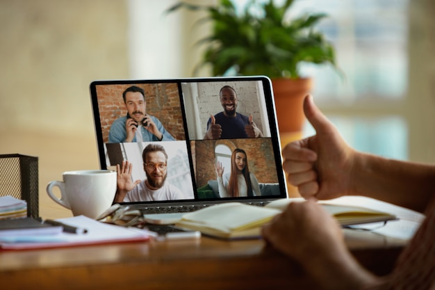 Businessman, manager in front of monitor during online conference with colleagues and team. Working from home during coronavirus or COVID-19 quarantine