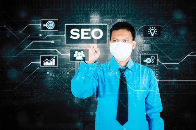 Businessman in mask touching a virtual SEO button