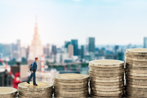 Businessman miniature standing on stack and tokyo city skyline background