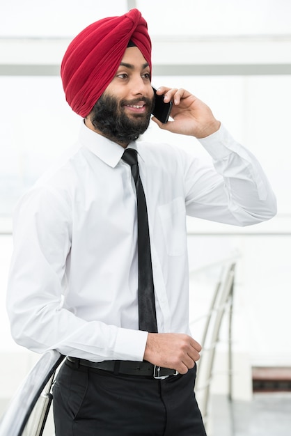 Businessman in modern office is talking by phone.