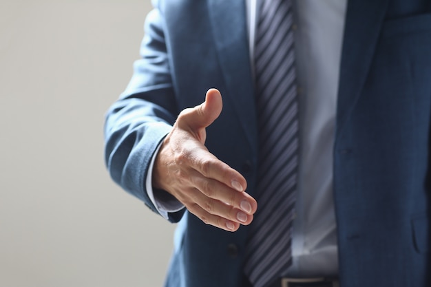 Businessman offer hand to shake as hello in office closeup