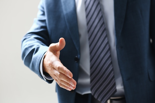 Businessman offer hand to shake as hello in office