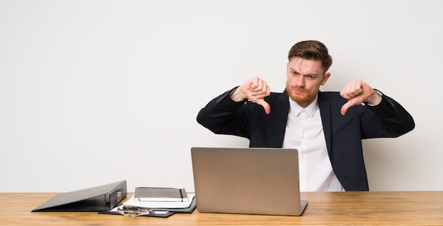 Businessman in a office showing thumb down