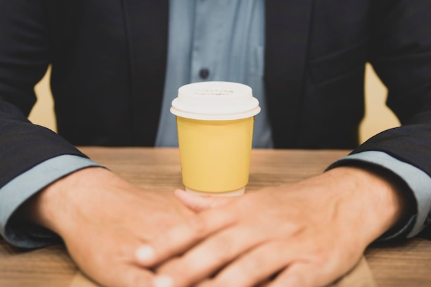 Businessman and paper yellow glass of coffee Front view Concept of coffee break