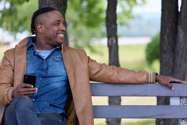 Businessman on a park bench with a mobile phone in his hand