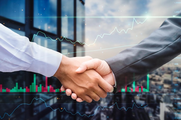 Businessman partnership handshake together on technical trading graph on business building