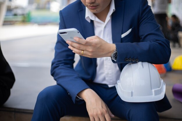 Businessman pass the time by using mobile smart phone outdoor.