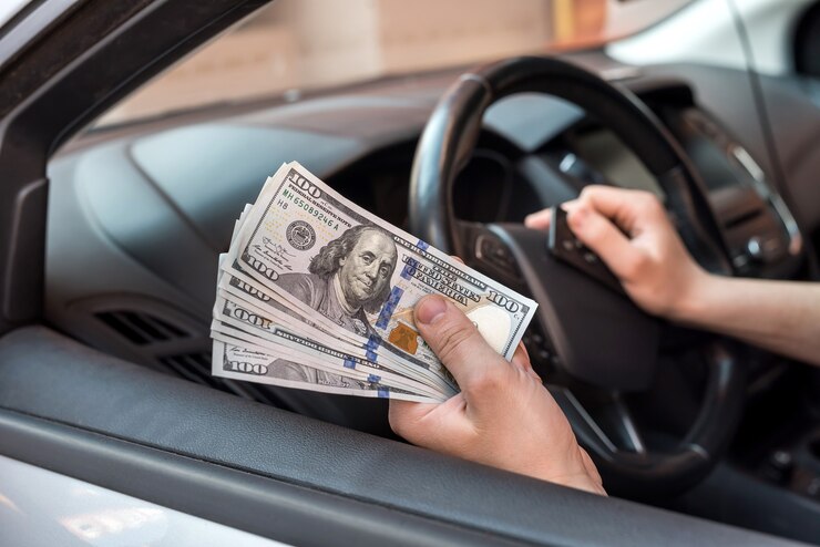 Photo ビジネスマンは、製品やサービスの料金を支払い、車に座っている間にドルを与えます。金融の概念