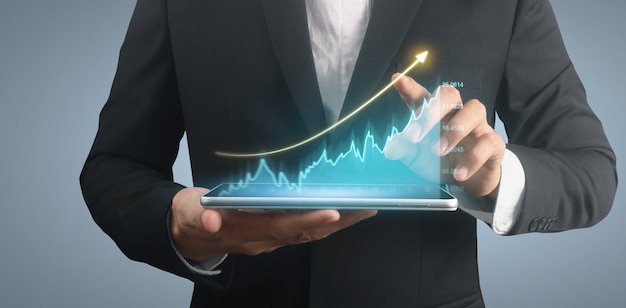 사업가 계획 그래프 성장 및 차트 긍정적 지표 증가, 손에 있는 태블릿
