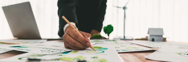 Businessman planning for green business strategy in office with paper documents focused on ecofriendly and energy sustainable policy to reduce CO2 emission for green environment Trailblazing