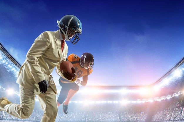 Businessman playing american football on the field. Mixed media