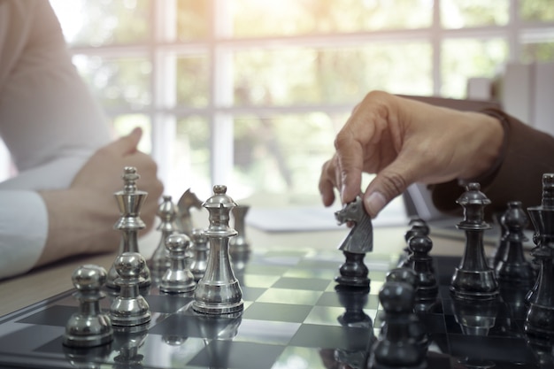 Businessman playing board chess game together. 