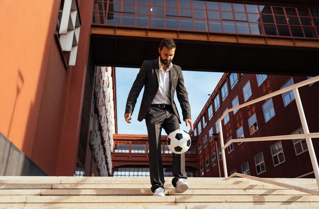 Businessman playing with a soccer ball and making freestyle tricks