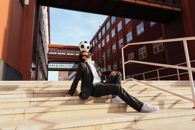 Businessman playing with a soccer ball and making freestyle tricks