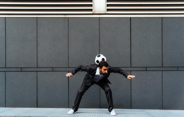 Businessman playing with a soccer ball and making freestyle tricks