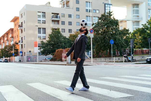 Businessman playing with a soccer ball and making freestyle tricks