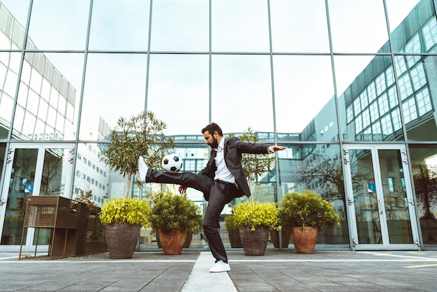 Businessman playing with a soccer ball and making freestyle tricks