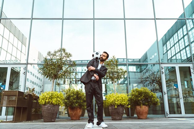 Businessman playing with a soccer ball and making freestyle tricks