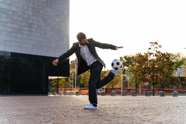 Businessman playing with a soccer ball and making freestyle tricks