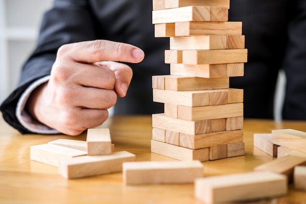 businessman playing the wood game, hands of executive placing block