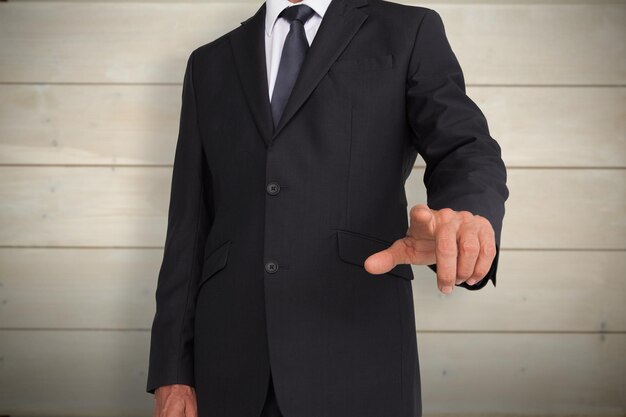 Businessman pointing against bleached wooden planks background