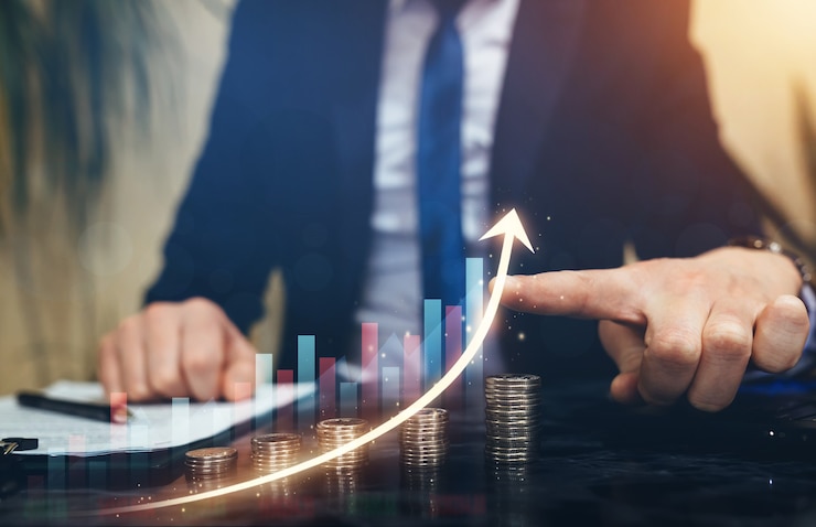 Photo businessman pointing  graph growth above stacks of coins. business development to success and growth plan investment.