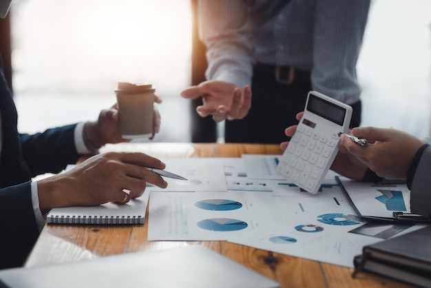 Businessman pointing graph and using calculator during a business meeting