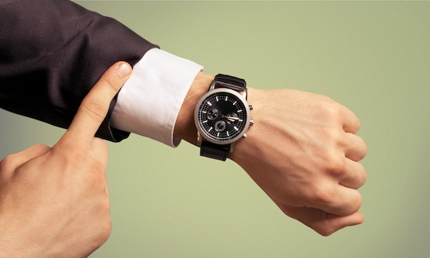 Businessman pointing at hand watch on white