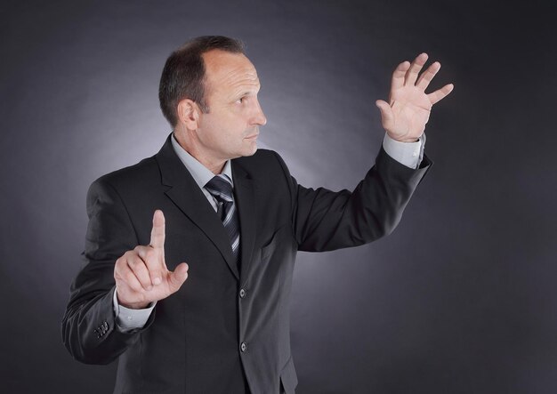 Businessman pointing at a virtual point photo on black background