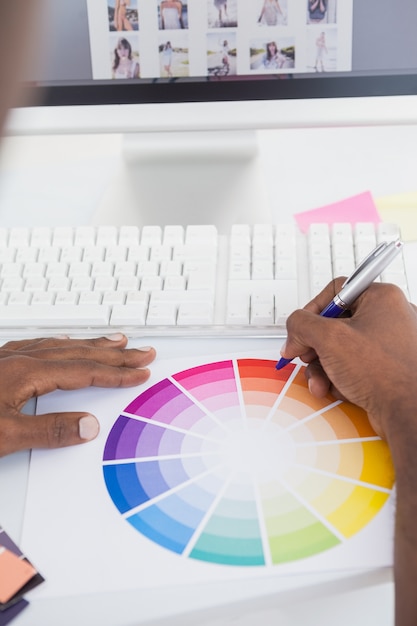 Businessman pointing with a pen on colour wheel