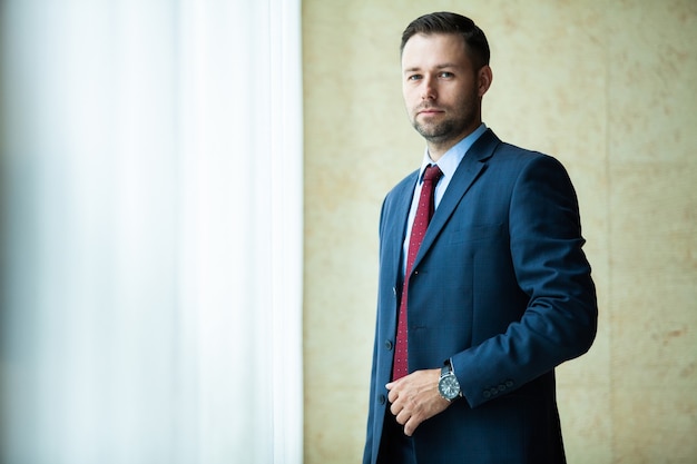 Businessman portrait. Happy confident young businessman standing arms crossed, smiling, looking at camera.