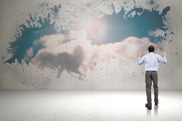 Businessman posing with hands up against splash showing cloudy sky