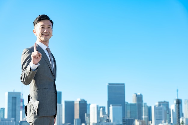 A businessman posing with his index finger up on fine day